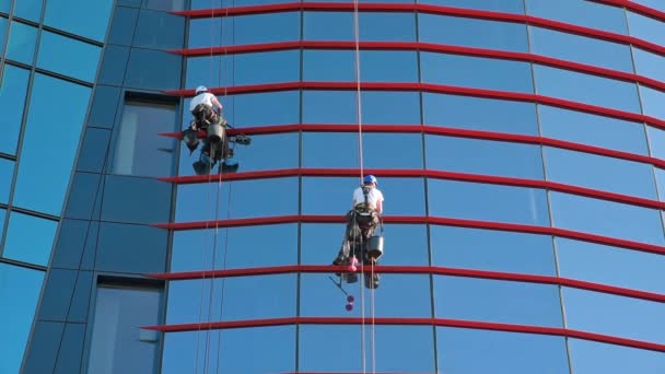 两名工人清扫商业中心的窗户 工业高山工洗刷摩天大楼的外部 危险的高风险工作 清洁服务 — 图库视频影像