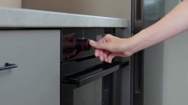 Kadın eli elektrikli fırın kontrol panelinde pişirme programı elektrikli fırın kullanan kadın, modern ev aletleri.