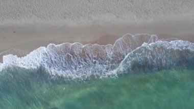 Sand beach with sea waves, top view. Summer vacation and travel concept. Beautiful coastline with blue sea and sand beach, aerial view