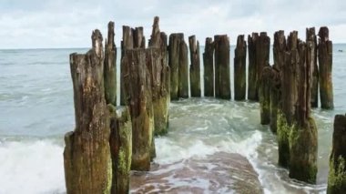 Baltic sea seachore with waves, breakwater and beautiful cloudy sky without people, Summer travel and vacation in Poland