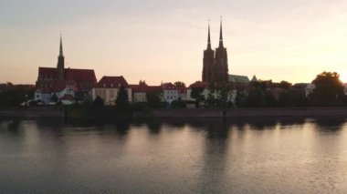 Drone flight over Tumski island and Cathedral of St John the Baptist in Wroclaw at morning sunrise light, Aerial view of old town with historical architecture in Wroclaw city, Poland