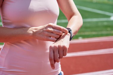 Woman use fitness watch before cardio exercises, Checking results on smart watch after training, Healthy lifestyle concept