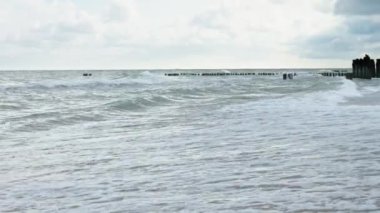 Baltic sea seachore with waves, sand beach and beautiful cloudy sky without people, Summer travel and vacation in Poland