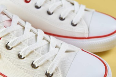 Female sport sneakers against yellow background, Casual trendy shoes closeup, Creative minimal design with copy space