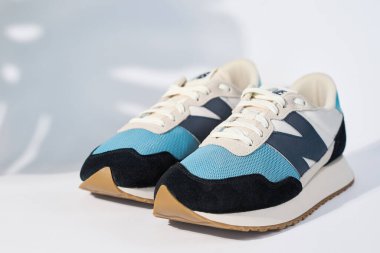 MS237HL1 model MS27HL1 marka şık ayakkabılar, bitki gölgeli beyaz arka plan, moda spor ayakkabılar, şık moda minimalizm konsepti. Wrocalw, Polonya - 08 Mayıs 2022