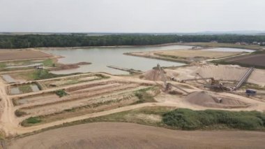 Kum madenciliği fabrikasında İHA uçuşu. Açık çukur ve kuvars kumu çıkarmak için taşıyıcı sistemlere sahip bir bitki. Ağır çöp kamyonlu taş ocağı.