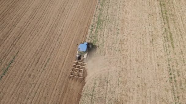 在农田里干活的拖拉机上盘旋的无人机 一排排一排排的灰尘 为丰收准备农田土壤 农业综合企业概念 — 图库视频影像