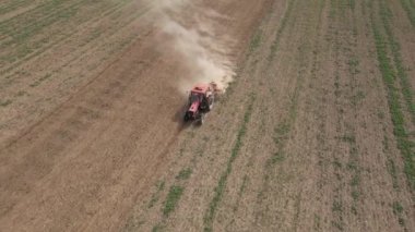 Tarımsal alanda çalışan tarım traktörü, toprak ekip biçmek ve sürmek, insansız hava aracı görüşü. Tarım sektörü konsepti. Küçük çiftçilik