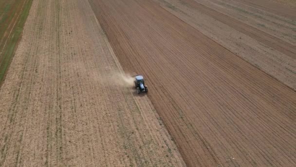 農業分野で働く農業用トラクター 耕起後のほこりの列上を飛行ドローン 良い収穫のための農地土壌の準備 農業ビジネスの概念 — ストック動画
