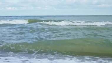 Baltic sea seachore with waves, sand beach and beautiful cloudy sky without people, Summer travel and vacation in Poland