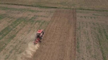 Tarımsal alanda çalışan tarım traktörü, toprak ekip biçmek ve sürmek, insansız hava aracı görüşü. Tarım sektörü konsepti. Küçük çiftçilik