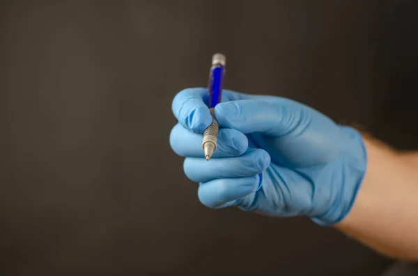 El guante médico azul sostiene el lápiz mecánico. Negro backgr —  Fotos de Stock