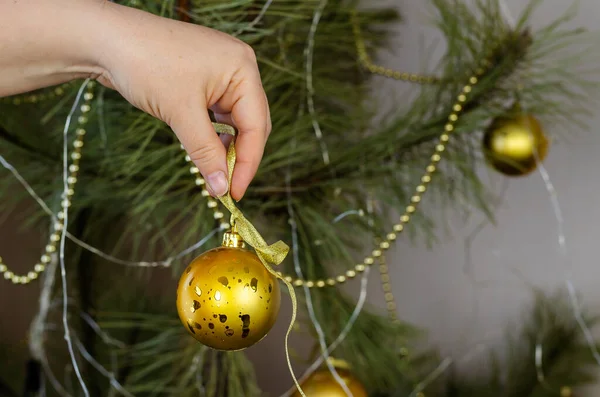 クリスマスツリーを飾る女性 大人の女性は枝にお祝いのボール ガーランド チンセルを掛けます 新年とクリスマスの休日 選択的焦点 — ストック写真
