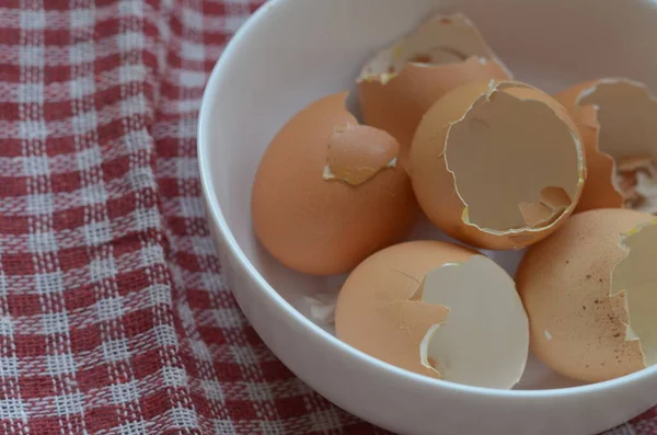 Egg shells from eaten eggs. Boiled chicken eggs. White ceramic bowl with broken shells. Close-up. Selective focus. Inside the room.