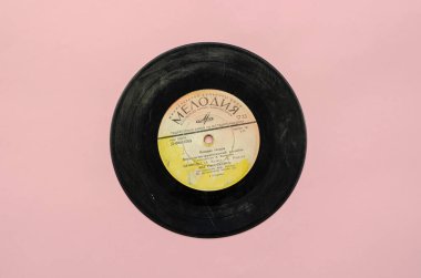 70 'lerin plakları. Pembe arka planda siyah gramofon kaydı. Sovyet grubu Singing Guitars 'ın şarkı koleksiyonu. Plak şirketi 