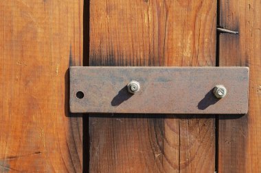 Üç tahta ve bir metal çubuk. Paslı dikdörtgen plaka. Kahverengi tahta. Seçici odak.