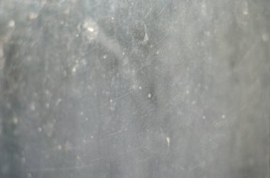 Odaklanma, gürültü, bulanıklık, tahıl etkisi. Açık gri şeffaf soyut arkaplan. Yüzeyde çizikler ve parıltılar var. Seçici odaklanma. Tasarımcı tabanı.