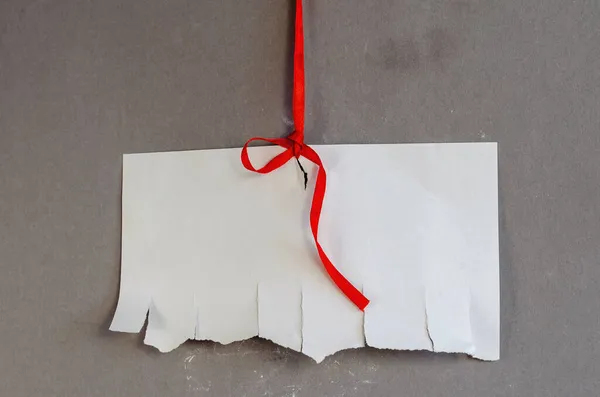 Wit Velletje Papier Met Afscheurstukken Rood Lint Tegen Een Grijze — Stockfoto