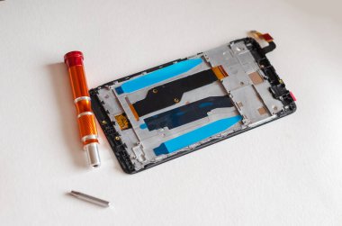 Parçalanmış akıllı telefon, el aletleri ve hafif bir yüzeydeki parçalar. Servis Tamiri. Seçici odak.