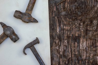 Paslı el aletleri. Üç çekiç ve kırık ahşap bir yüzey üzerinde bir yaprak kağıt. Üst Manzara. Seçici odak.