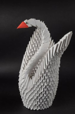Japon modüler origami. Siyah arka plana karşı beyaz kağıt kuğu. Yaratıcılık sanatı hobisi. Seçici odak