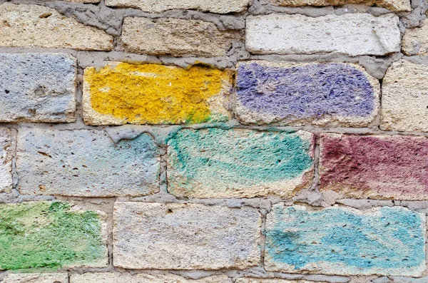 The exterior wall of the building painted by children. A stone wall painted with colorful paints and crayons. Outside. Selective Focus.