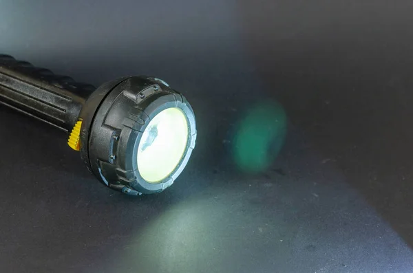 灰色の背景に古い黒の手のランプを光る 黄色いスイッチ付きの大きな懐中電灯 選択的焦点 — ストック写真