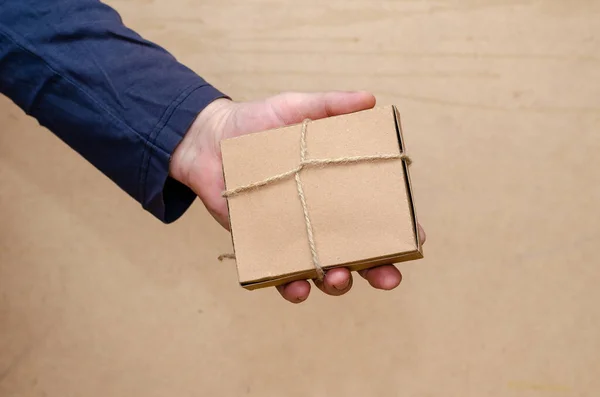 一个成年男子手里拿着一个棕色礼品盒 矩形纸板箱用绳子捆扎 有选择的重点 — 图库照片