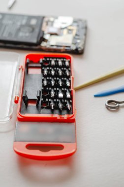 Parçalanmış akıllı telefon, el aletleri ve hafif bir yüzeydeki parçalar. Servis Tamiri. Seçici odak.