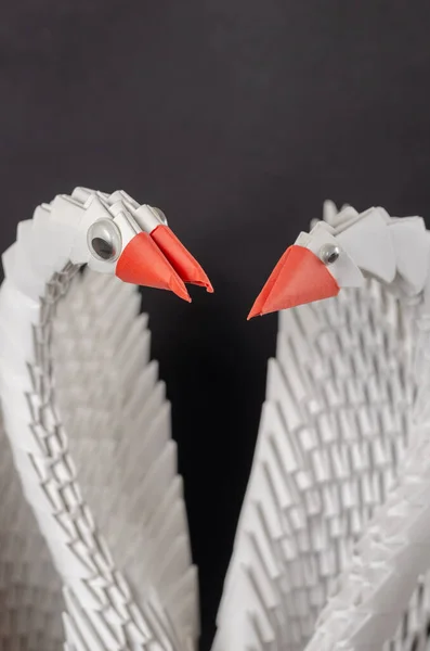 Close-up of a pair of white paper swans. A symbol of love and fidelity. Modular origami or unit origami. Creativity skill hobby art. Selective focus