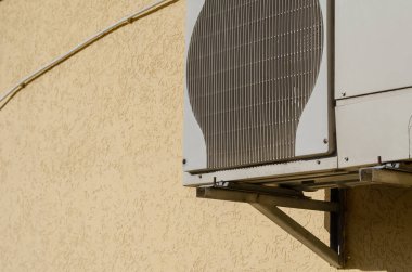 Sarı duvara karşı açık hava klima ünitesi. Gündüz vakti. Seçici Odaklanma. Kimse yok..