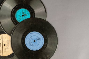 Gri arka planda 1950-1970 yılları arasında yapılmış vinil plaklar. Eski Sovyet şarkıları kullanılmış gramofon plakları. Kiev, Ukrayna - 04 15 2021