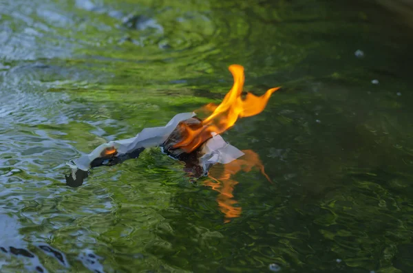 白い紙が川の下に浮かんでいる ビジネス文書が炎に包まれています 燃えるような動き 選択的焦点 — ストック写真