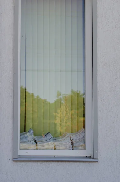 Stack of questionnaires, medical tests, business or accounting documents lie on the windowsill outside the window. Access to personal data or unsuitable storage of documentation concept.