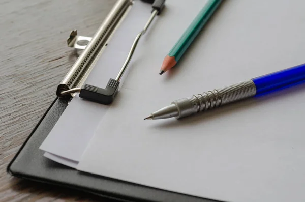 钢笔和木制铅笔放在剪贴板上 有选择的重点 — 图库照片