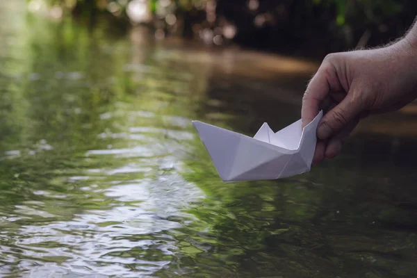 Une Main Abaisse Bateau Papier Blanc Sur Eau Homme Tient — Photo