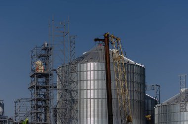 İnşaat alanı. Tahıl deposu için silindirik silo kurulumu. Metal modern asansör. Endüstri. Tarım işi. Seçici odak.