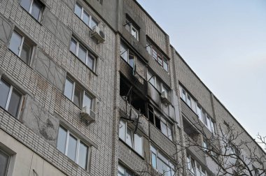 Bir apartmanda sönmüş bir yangın. Kırık camları olan yanmış bir balkon. Duvarlarda siyah is var. Yangın hasarı ve yaralanma. İnsan yok. Seçici odak.