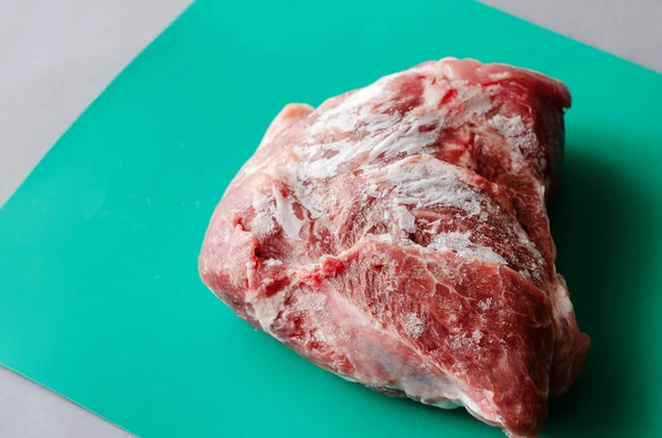 Large Piece Frozen Meat Pork Sirloin Butt Green Background Selective — стоковое фото