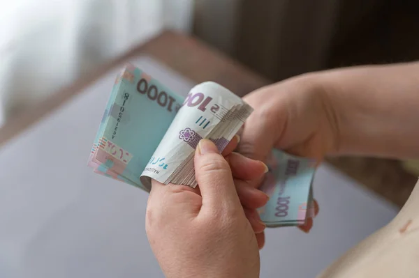 一个成年女人在屋里数钱 她的手拿着一束乌克兰赫里夫尼亚 000格里夫尼亚面额的钞票 有选择的重点 — 图库照片