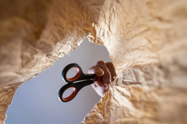 Una Mano Mette Forbici Sacchetto Carta Mano Uomo Maturo Tiene — Foto Stock