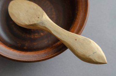 Kahverengi toprak kap ve gri arka planda saçmalar. Ahşap kaşık oymak için boş bir kase ve bir kaşık. Seçici odak.