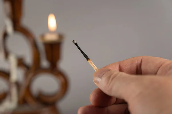 Mão Homem Segura Fósforo Extinto Contra Velas Acesas Castiçal Cerâmica — Fotografia de Stock