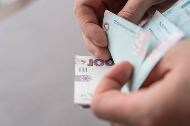 Erkeklerin para saydığı yakın plan çekimler. Yetişkin bir erkek Ukrayna banknotlarını sayar. 1000 hryvniadan oluşan nakit para. Seçici odak.