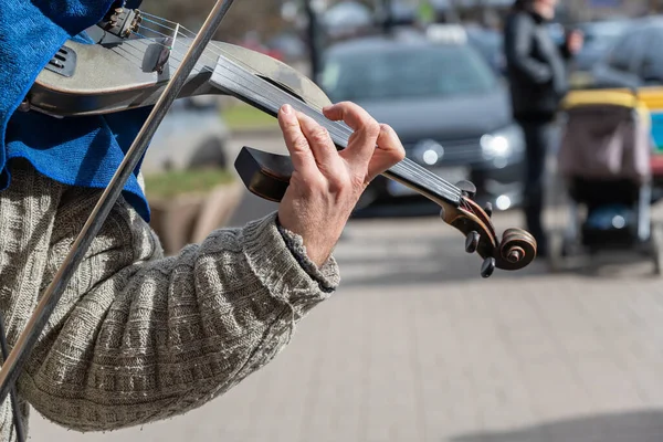 コンサート中のストリートミュージシャンの手のクローズアップ 成熟した男再生電子バイオリン — ストック写真