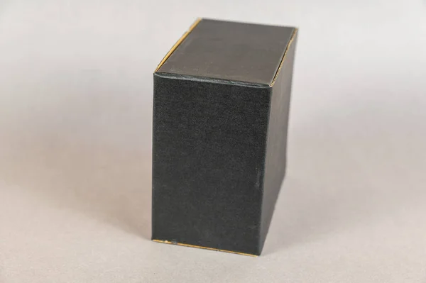 灰色背景上的矩形黑匣子 形状正确的封闭式纸板包装 — 图库照片