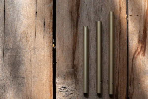 Три Зелених Алюмінієвих Трубки Дерев Яному Фоні Грубі Потріскані Дошки — стокове фото