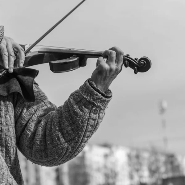 コンサート中のストリートミュージシャンの手のクローズアップ 成熟した男は電子バイオリンを演奏 白黒写真 都市生活 — ストック写真