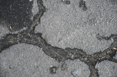Eskimiş ve çatlamış asfalt çatlaklar. Hasarlı bir yol yüzeyinin dokusu.