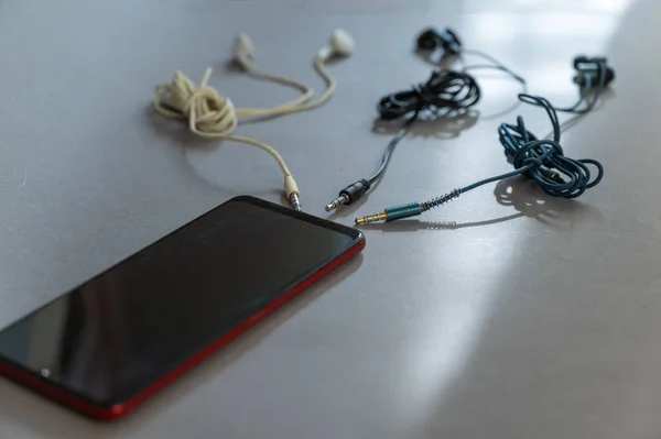 Smartphone Και Ενσύρματα Ακουστικά Φόντο Γκρι Φόντο Πολύχρωμα Ακουστικά Φιλοδοξούν — Φωτογραφία Αρχείου